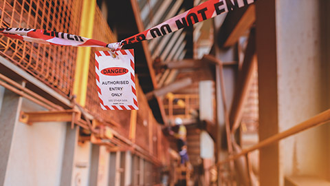 Red and white danger tag indicating exclusion zone on construction site