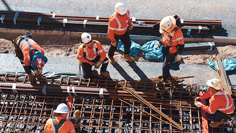 A group of construction workers preparing formwork for concrete pouring