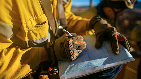 A close view of a construction worker filling out paperwork relating to the job