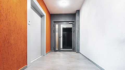 A view down a hallway of a modern apartment complex with a fire door