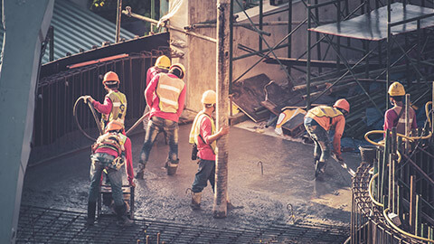 A group of construction workers pouring concrete on a building site