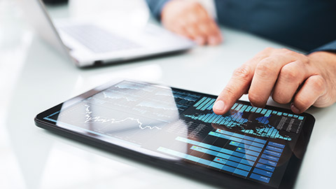 A close view of a person looking at financial information displayed on a tablet device