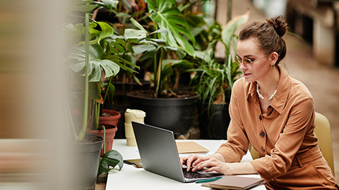 An accountant entering information on a laptop while sitting in a modern office space