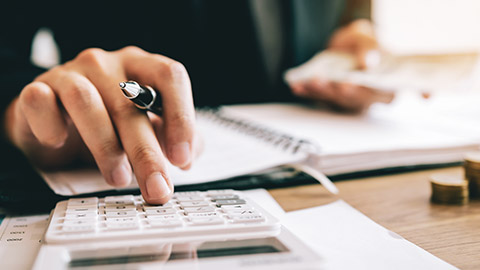 A close view of a business owner using a calculator