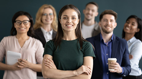 Different age and ethnicity businesspeople standing behind of female company chief business owner with hands crossed posture of confident independent businesswoman leader of multi-ethnic team concept