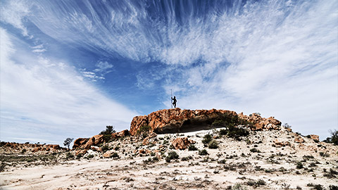 An indegenous man on top of a rock