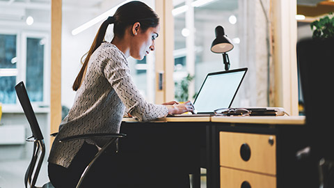 A business manager working on files on a laptop