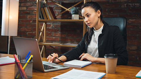 Young woman working in modern office using devices and gadgets