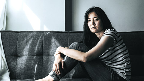 sad woman sitting on sofa