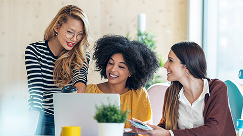 Shot of casual multiethnic business women working with laptops while talking of they new projects together in coworking place.