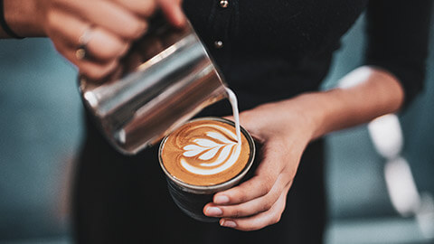 A barista making a coffee for a customer