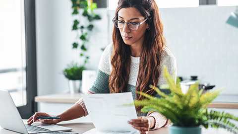 A business owner entering financial records on a laptop