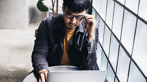 a person looking intently at laptop