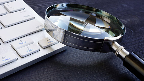 A magnifying glass on a keyboard