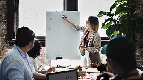 A person analysing process in a white board for a group