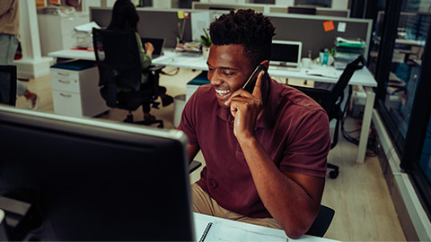 An employee talking on a phone to a customer