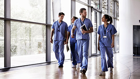 A row of medical proffesionals talking while walking