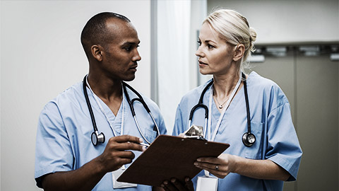 Two medical professionals seriously discussing a patient