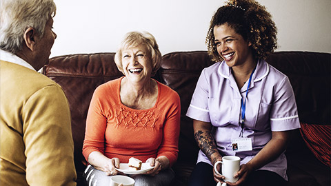 A carer having tea with clients