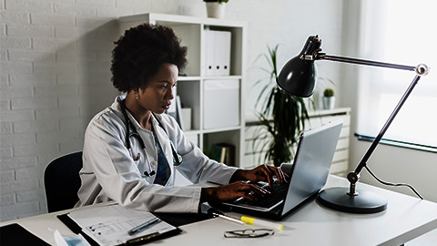 A doctor organizing digital data in a laptop