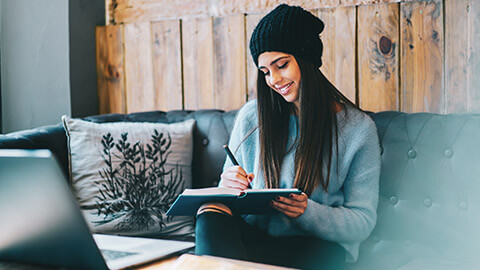 A young designer sitting in a relaxed location working on ideas for a website