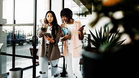 a couple of employees talking about work while walking in the office