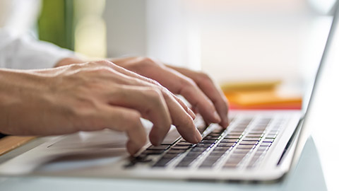 A person typing on a laptop