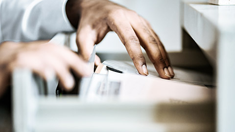 Hands sorting document on storage