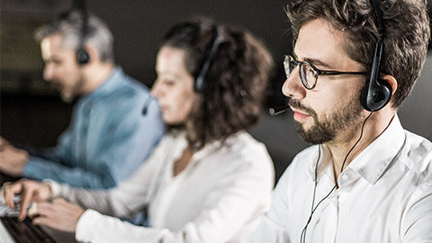 Concentrated bearded call center operator working. Thoughtful call center operators during working process. Call center concept