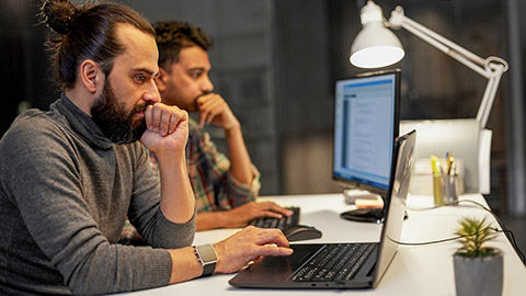 deadline, technology and people concept - creative team with computers working together late at night office