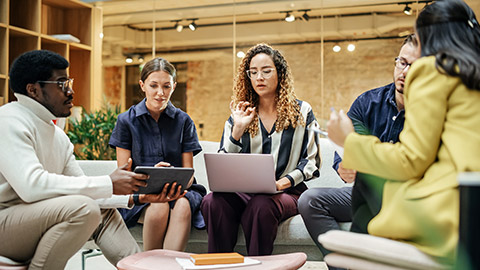 Diverse People in an Office Talking and Agreeing While Pointing at Tablet Screen.