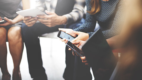 A group of people accessing information on multiple devices