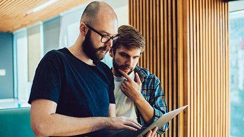 2 colleagues watching content on a laptop computer