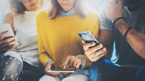 A group of people accessing information on multiple device types