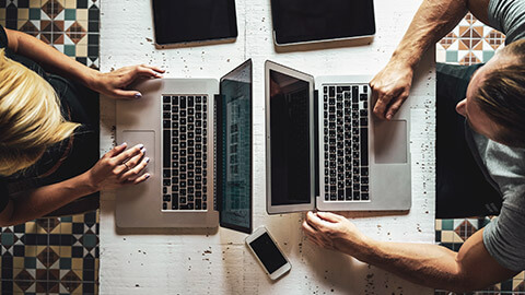 Top down view of a digital marketers working on different mobile devices