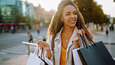 woman with shopping bags walking on street