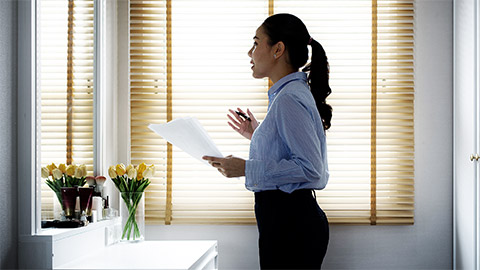 A person practicing speaking at the mirror