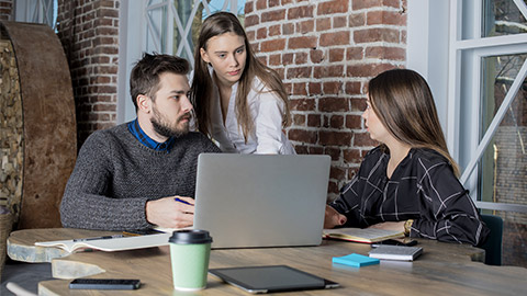 Business team working together, talking about important issues using laptop computer.