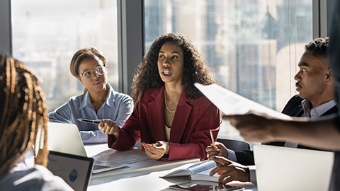 Presenting idea. Inspired black african woman employee propose marketing plan to interested diverse colleagues on briefing.