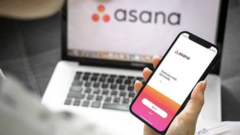 Asana logo on mobile and laptop screen