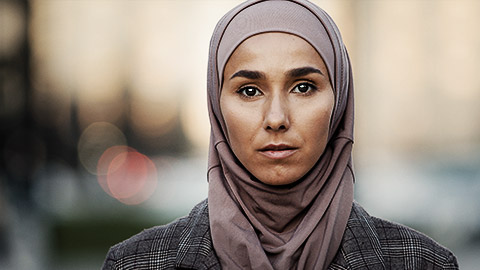 A pensive muslim female looking into camera