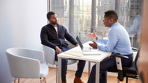 Man Meeting With Male Financial Advisor Relationship Counsellor In Office