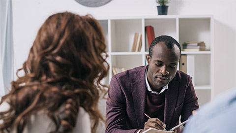 African american psychiatrist writing in textbook