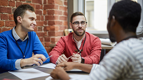 men sitting by table in office at start-up meeting and brainstorming