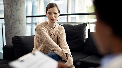 Young sad woman having a counseling with psychotherapist at doctor's office