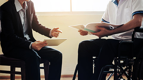 A counselor talking to a disabled client