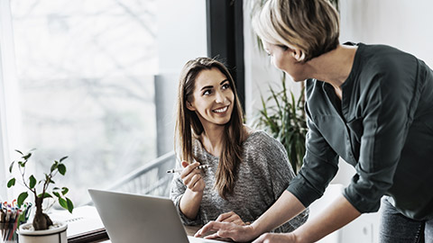 Two females talking with computer