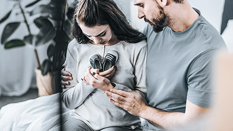 Couple hugging small shoes