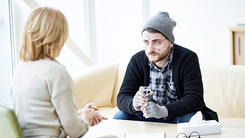 Psychology counselling of a man,holding glass of water