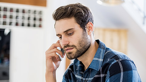 Man talking on mobile phone at home